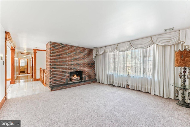 unfurnished living room with a brick fireplace and light colored carpet