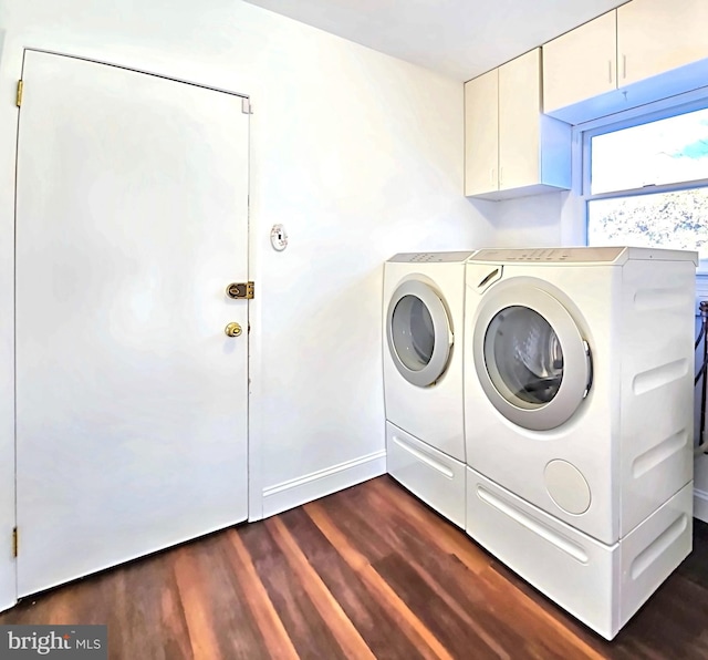 laundry room featuring cabinets, dark wood-type flooring, and washer and dryer