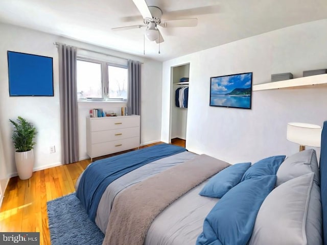 bedroom with hardwood / wood-style flooring, ceiling fan, and a closet