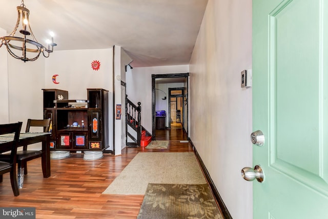 corridor featuring a notable chandelier and hardwood / wood-style flooring