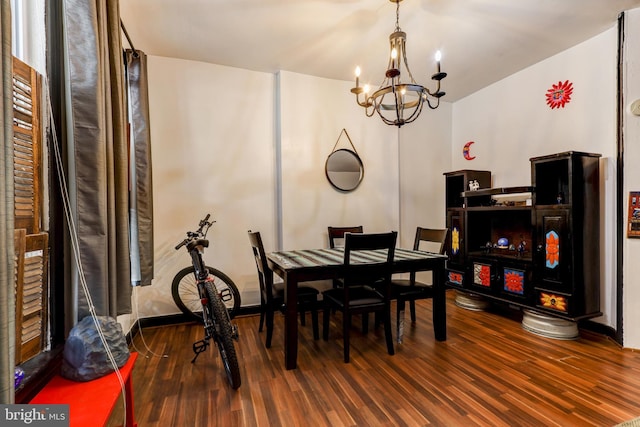 dining space with an inviting chandelier and dark hardwood / wood-style flooring