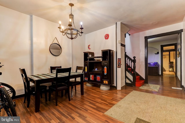 dining room with an inviting chandelier and dark wood-type flooring