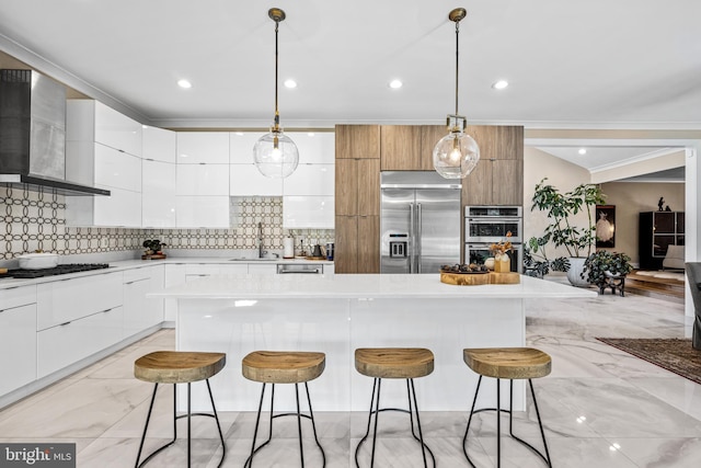 kitchen with white cabinets, a center island, wall chimney exhaust hood, and appliances with stainless steel finishes