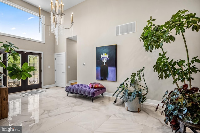 foyer entrance with a notable chandelier and a towering ceiling