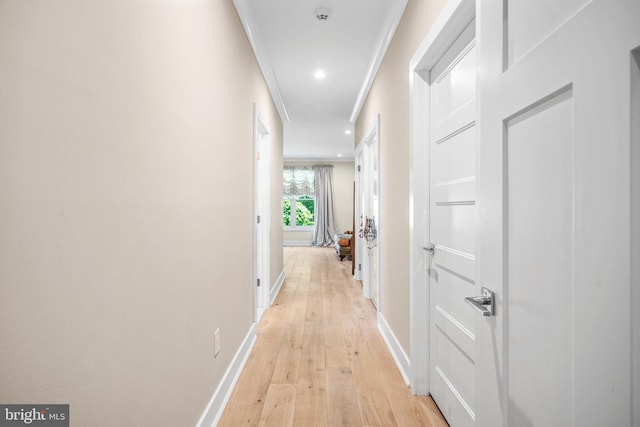 corridor with crown molding and light wood-type flooring