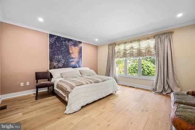 bedroom with crown molding and light wood-type flooring