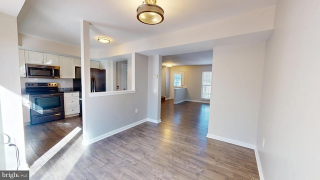 kitchen with hardwood / wood-style floors, appliances with stainless steel finishes, and white cabinetry