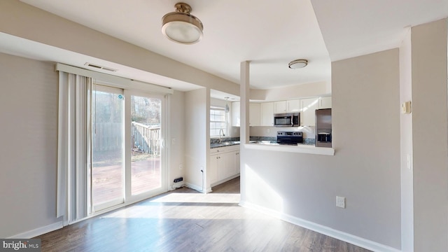 kitchen featuring white cabinets, light wood-type flooring, stainless steel appliances, and sink