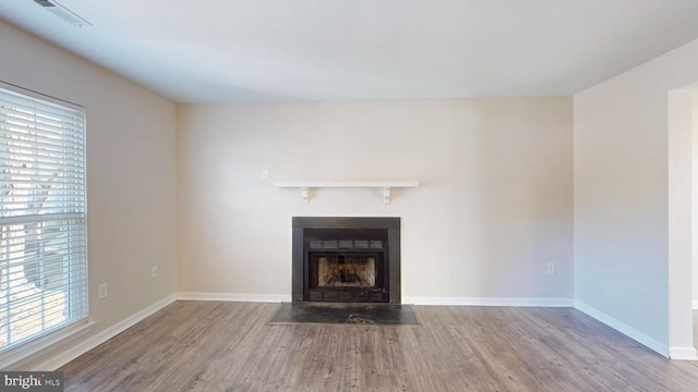 unfurnished living room featuring plenty of natural light and wood-type flooring