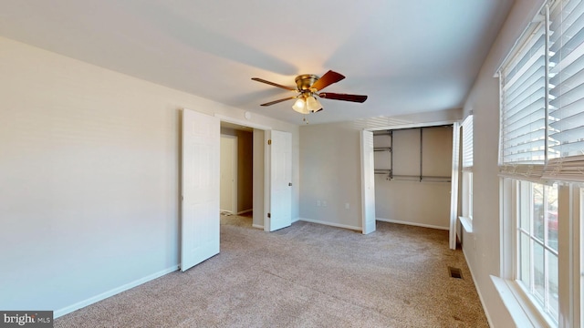 unfurnished bedroom with a closet, light carpet, and ceiling fan