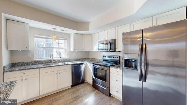 kitchen featuring light wood-type flooring, white cabinetry, stainless steel appliances, and sink