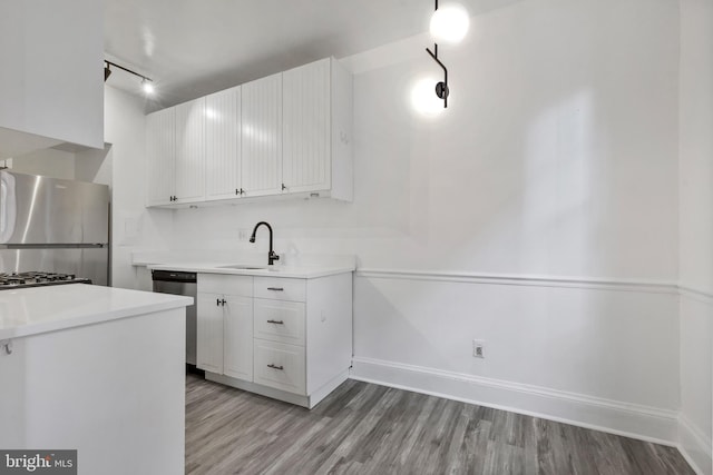 kitchen featuring sink, stainless steel appliances, white cabinets, and light wood-type flooring