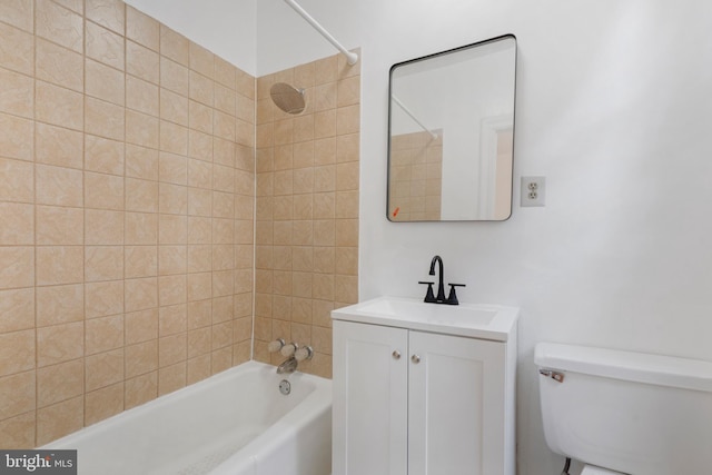 full bathroom featuring tiled shower / bath, vanity, and toilet