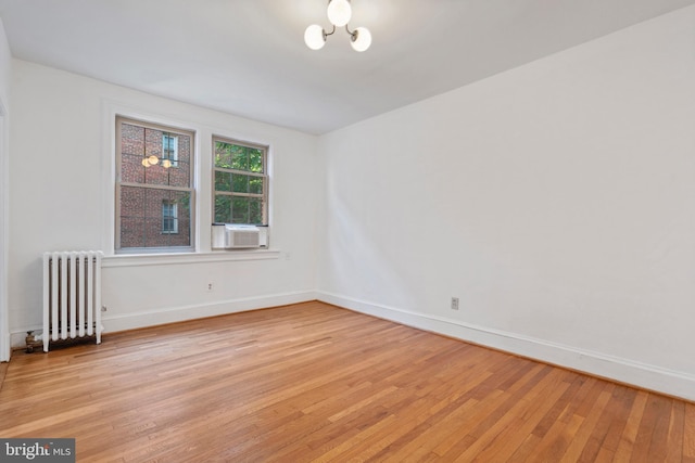 spare room featuring radiator and light wood-type flooring