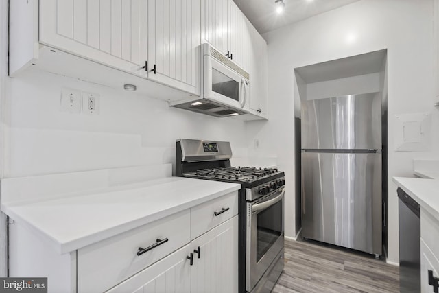 kitchen with white cabinetry, appliances with stainless steel finishes, and light hardwood / wood-style flooring