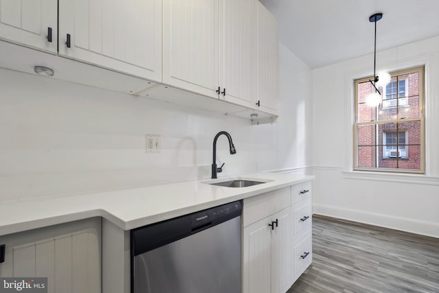 kitchen with sink, white cabinetry, hanging light fixtures, dishwasher, and hardwood / wood-style flooring