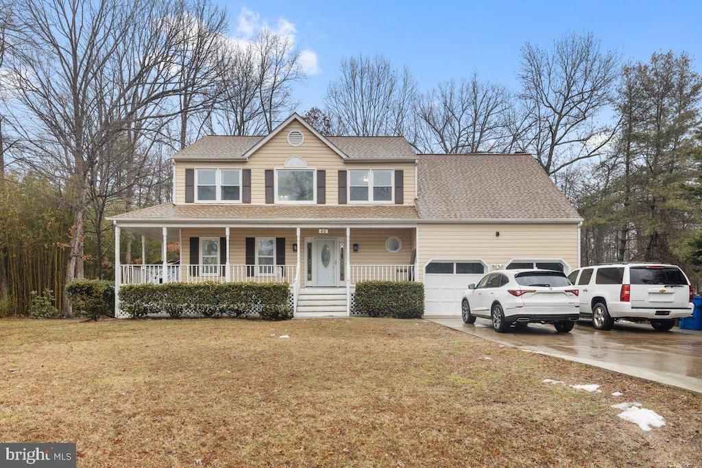 view of front of house with a garage, a porch, and a front yard