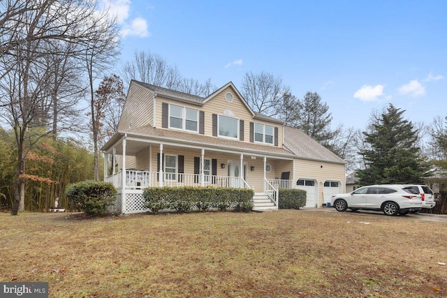 view of front of property featuring a garage, a front yard, and a porch