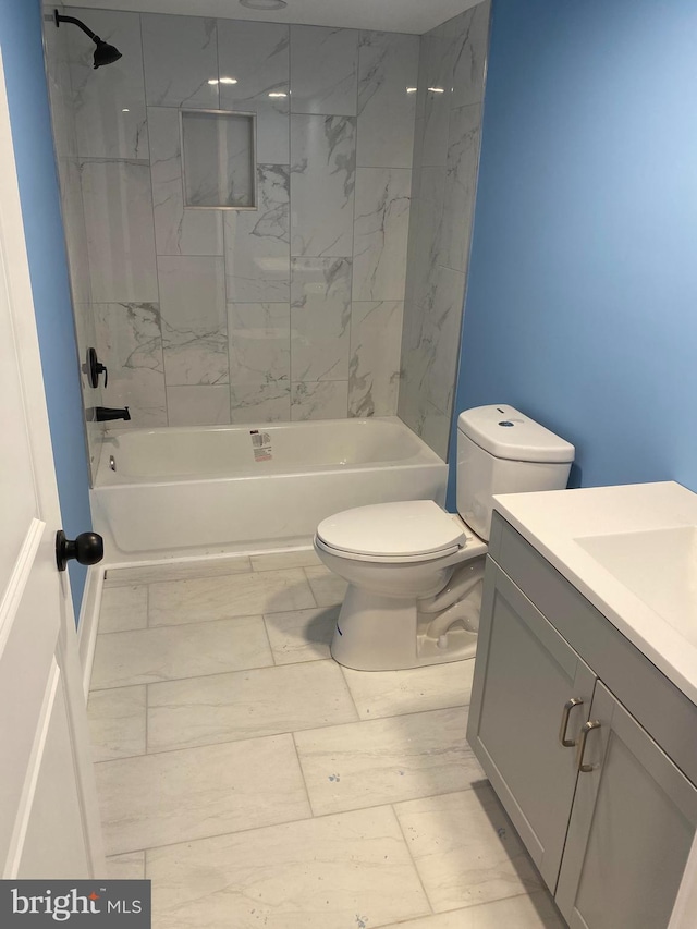 full bathroom featuring toilet, vanity, and tiled shower / bath