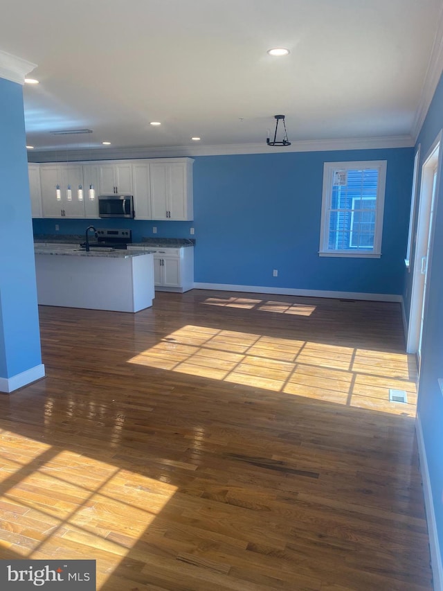 interior space featuring sink, wood-type flooring, appliances with stainless steel finishes, white cabinets, and crown molding