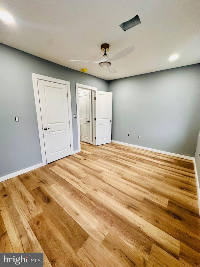 unfurnished bedroom with ceiling fan and light wood-type flooring