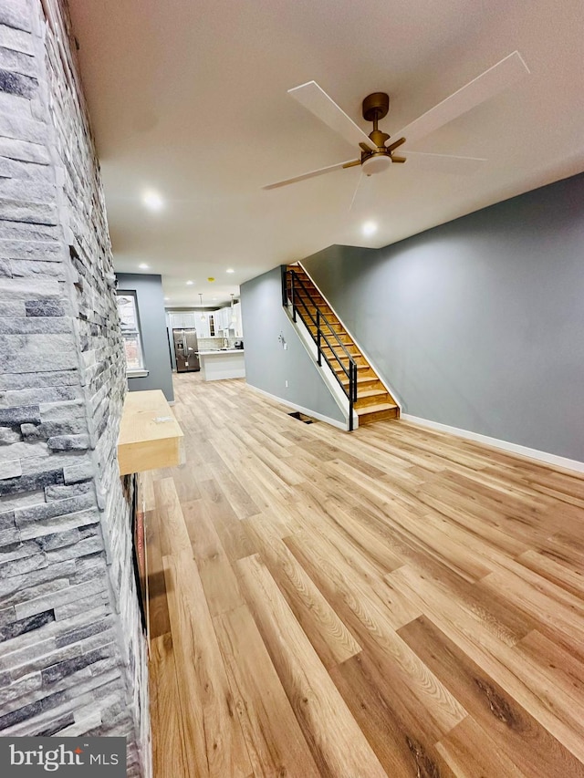 unfurnished living room with light hardwood / wood-style flooring and ceiling fan