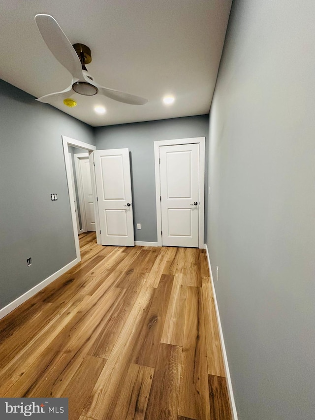 unfurnished bedroom with ceiling fan and light hardwood / wood-style floors