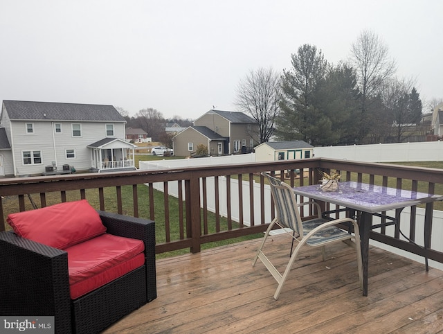 deck featuring a storage shed and a lawn