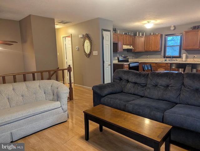 living room featuring sink and light hardwood / wood-style floors