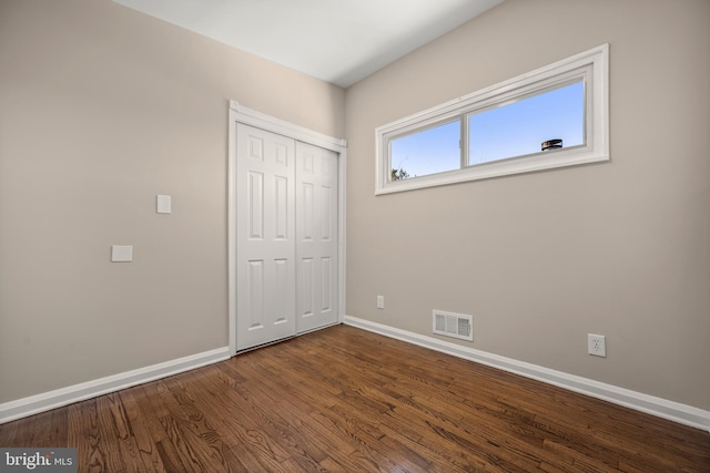 unfurnished bedroom with hardwood / wood-style flooring and a closet