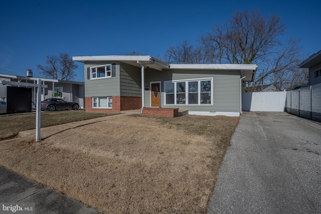 tri-level home with a carport and a front lawn