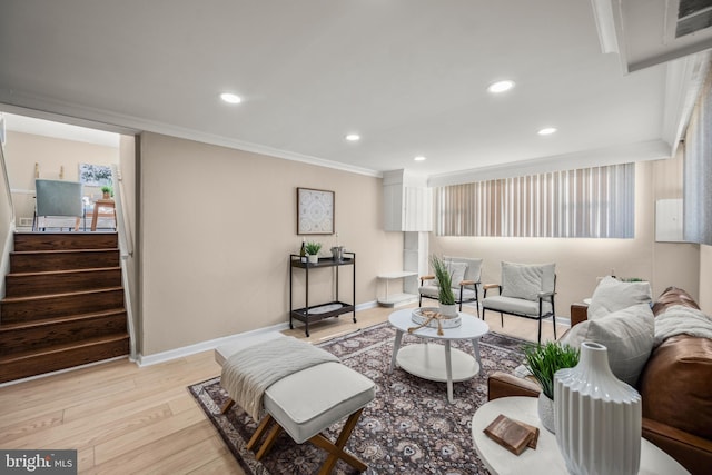 living room with ornamental molding and light hardwood / wood-style floors