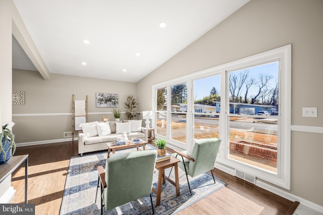 living room with hardwood / wood-style flooring and vaulted ceiling