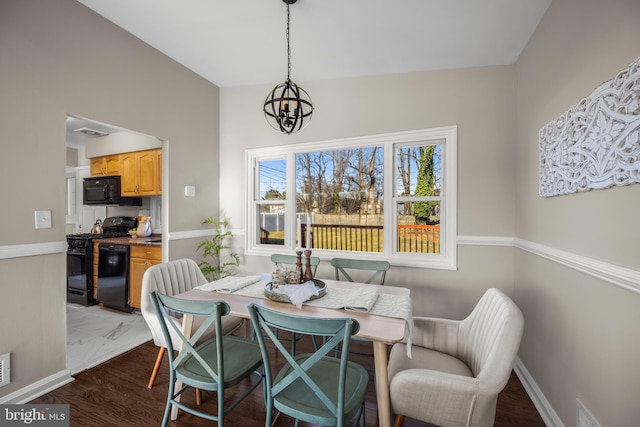 dining space featuring hardwood / wood-style floors and a notable chandelier