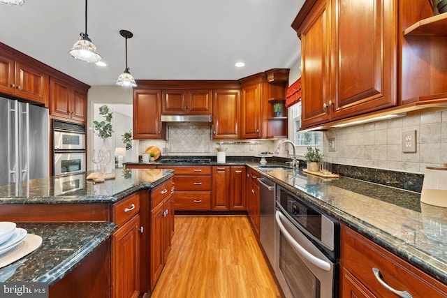 kitchen with decorative backsplash, hanging light fixtures, stainless steel appliances, open shelves, and a sink