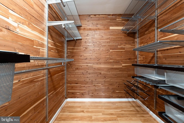 walk in closet with wood finished floors