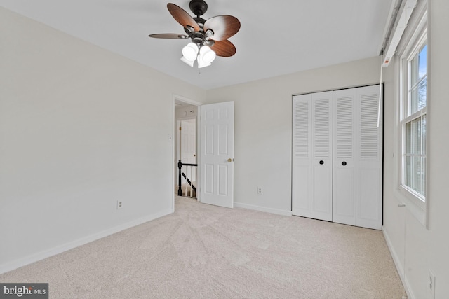 unfurnished bedroom with a ceiling fan, a closet, carpet flooring, and baseboards