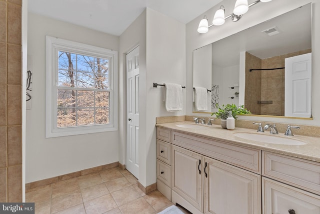 full bathroom featuring visible vents, a sink, a tile shower, and double vanity