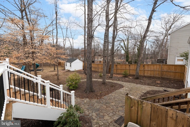 view of yard with an outbuilding, a fenced backyard, and a storage unit