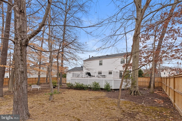 back of house with a fenced backyard and a wooden deck