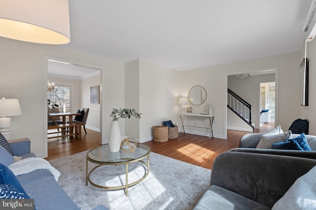 living room featuring stairs, baseboards, and wood finished floors