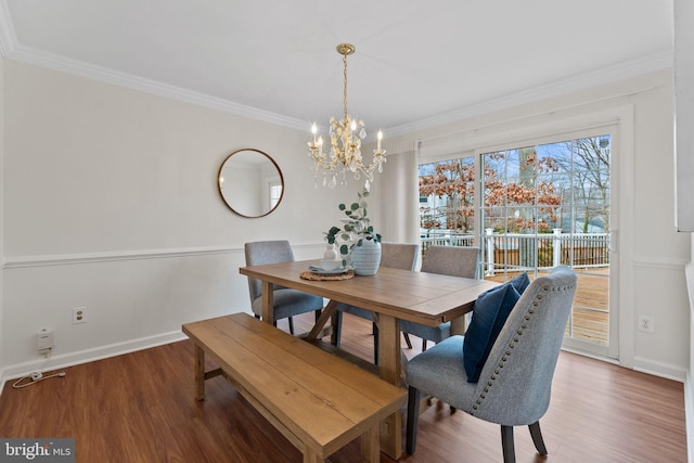 dining room with crown molding, baseboards, and wood finished floors