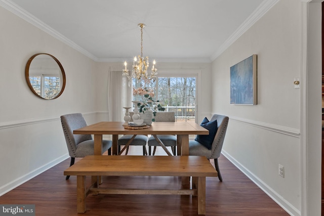 dining area with a notable chandelier, crown molding, baseboards, and wood finished floors