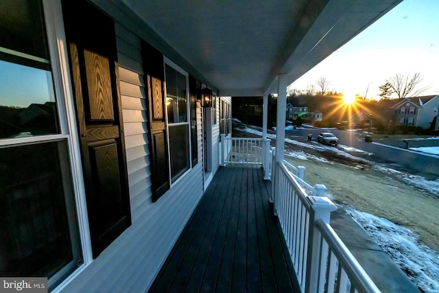 balcony at dusk featuring a porch