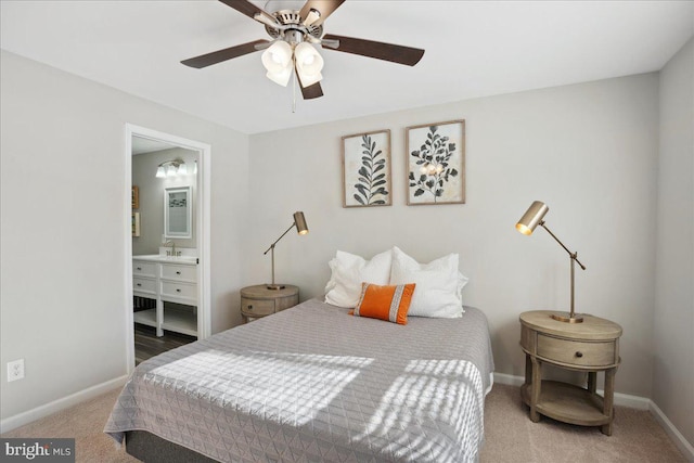 bedroom with sink, ensuite bath, carpet floors, and ceiling fan