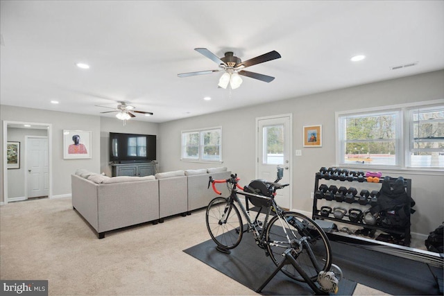 exercise area with light colored carpet and ceiling fan