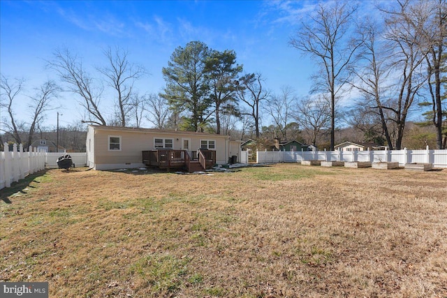 rear view of property with a deck and a lawn