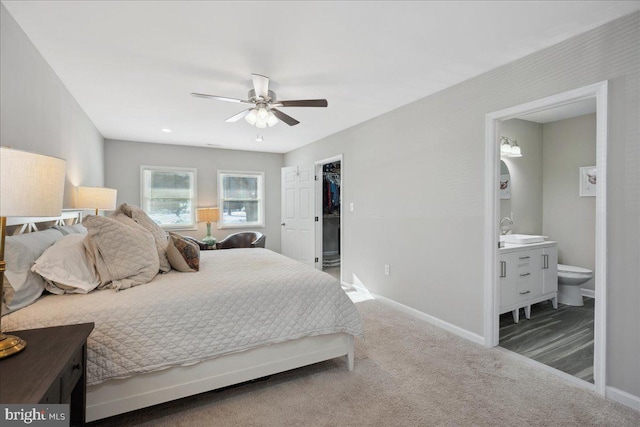 carpeted bedroom featuring ensuite bathroom and ceiling fan