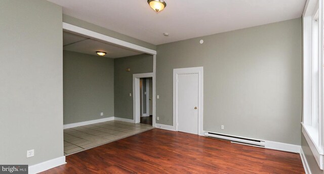 1812 Mcculloh St, Baltimore, MD 21217 - empty room featuring baseboard heating, wood finished floors, and baseboards