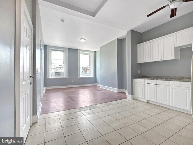 1812 Mcculloh St, Baltimore, MD 21217 - kitchen with light tile patterned flooring, ceiling fan, baseboards, and white cabinetry